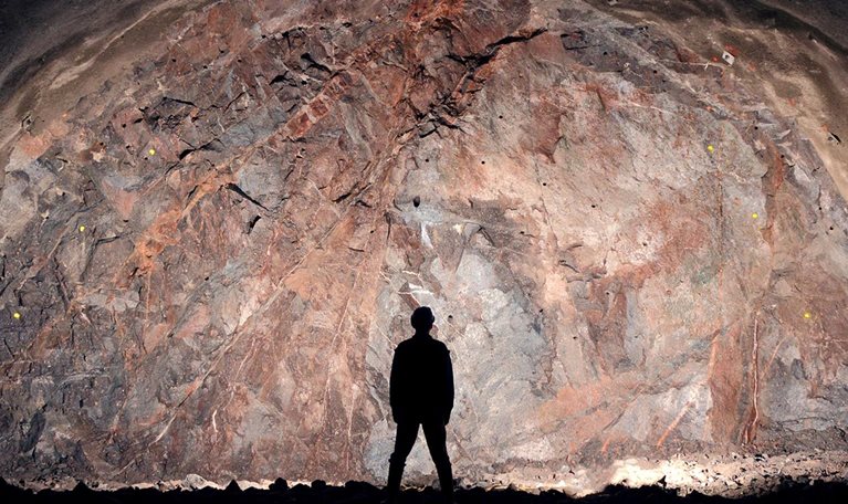 Mine, tunnel front, silhouette of a standing worker