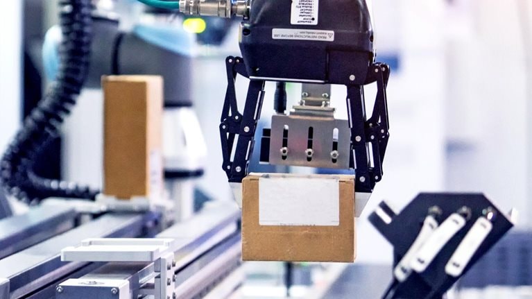 Robot picking a box in a manufacturing factory.