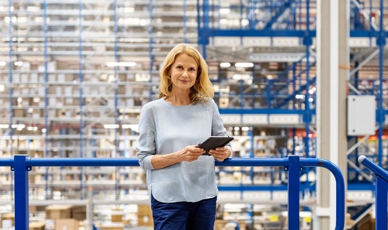 Portrait of a mature supervisor with digital tablet at warehouse - stock photo