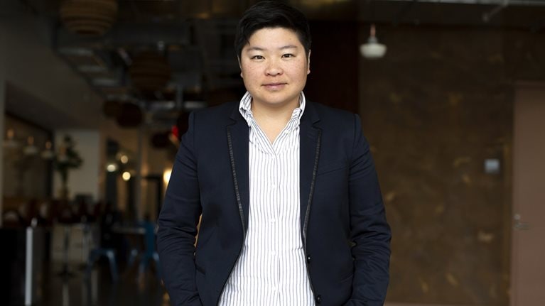 A photo of Jen Wong wearing a striped shirt and dark blazer