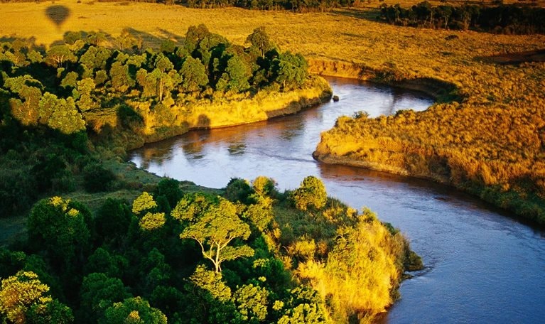 The view from the air, on a balloon safari over Masai Mara National Reserve in Kenya. The shadow of the balloon can be seen in the distance. - stock photo