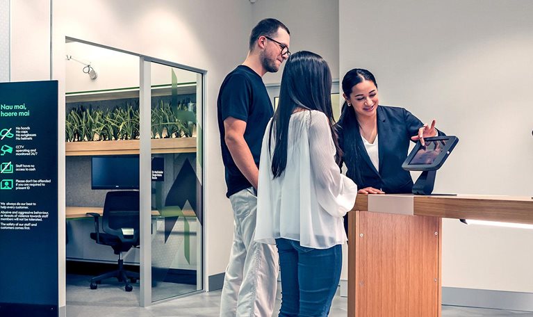 Kiwibank staff helping customers using a tablet