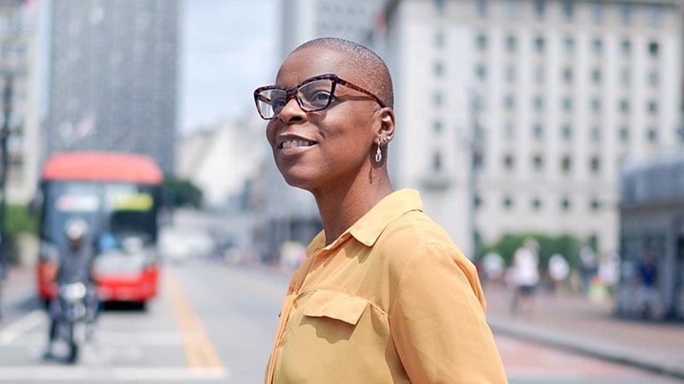 A person crossing the street holding a coffee cup