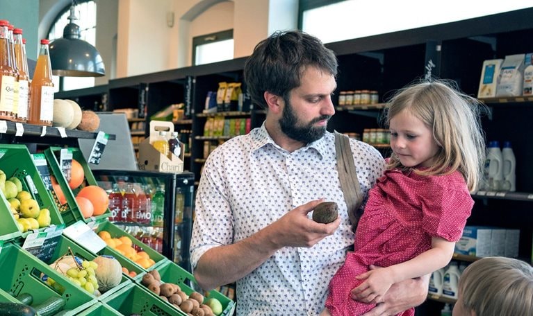 A father with his children in a retail store isle holding a displayed item