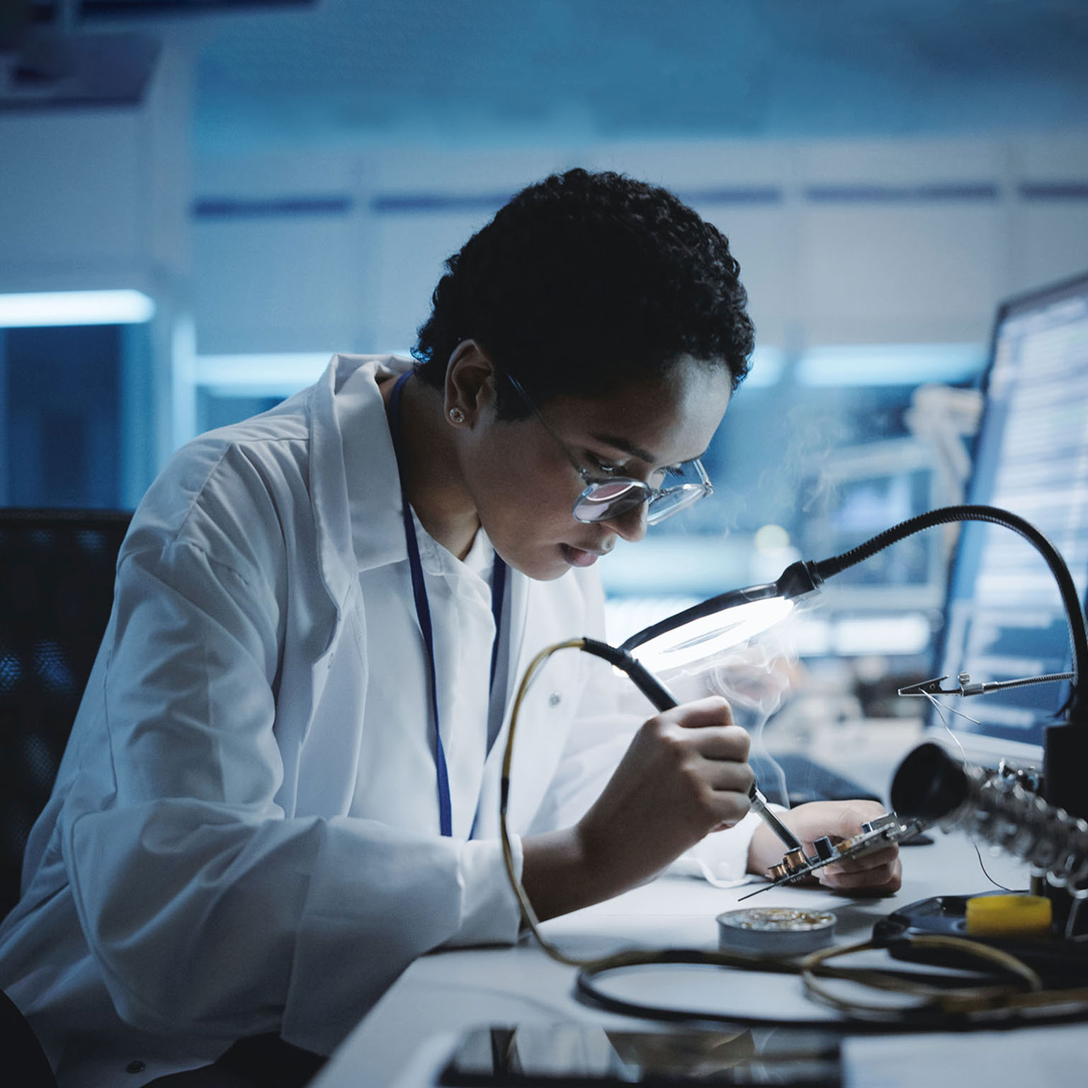 Black female engineer does computer motherboard soldering