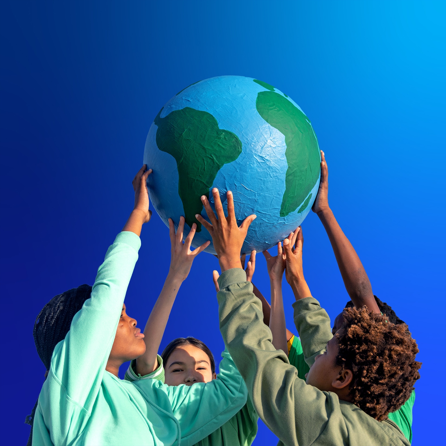 Group of children working together to hold up the world - stock photo