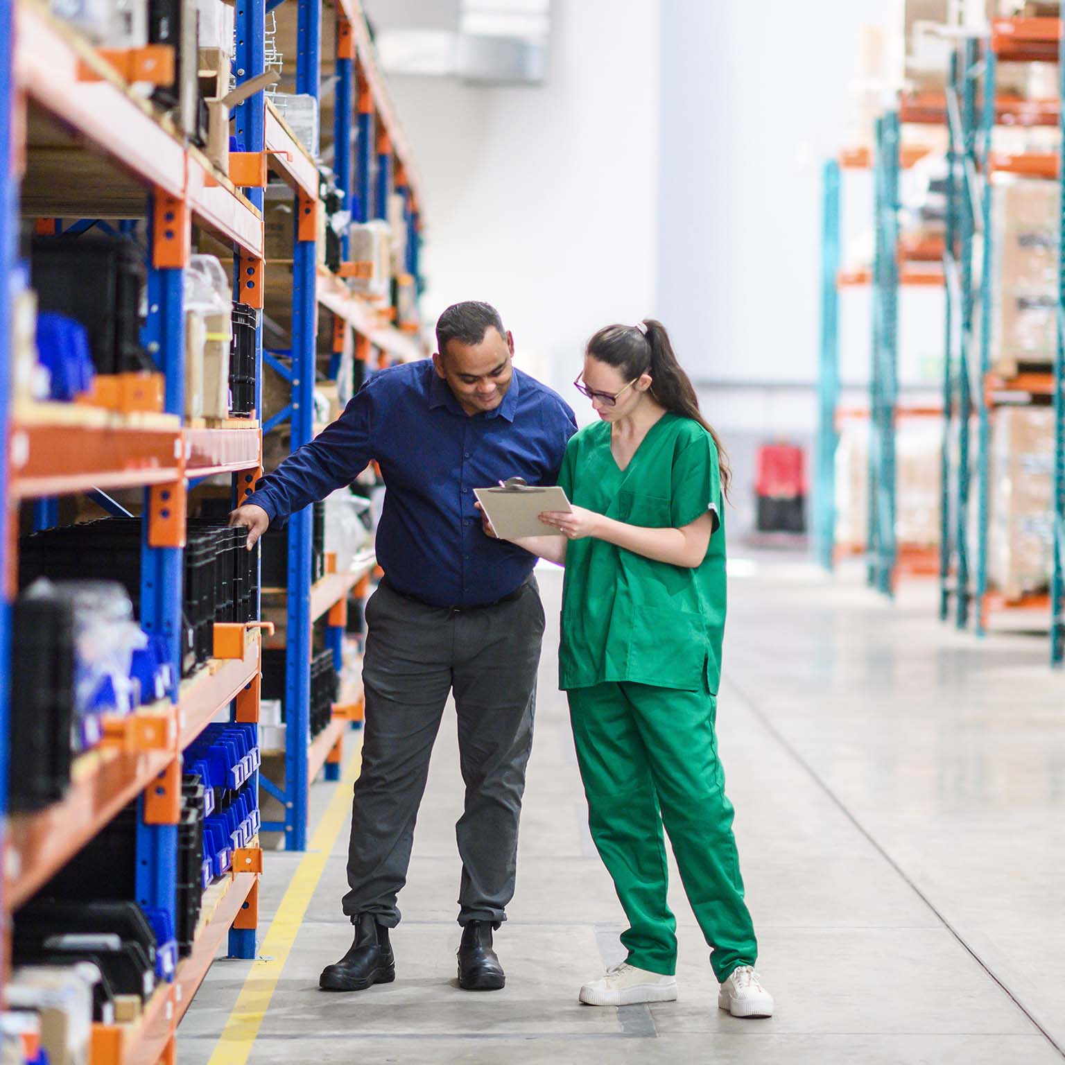 Warehouse workers managing medical inventory in organized storage facility with modern equipment.