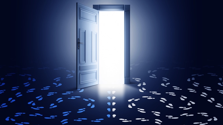 A glowing, open doorway with two sets of footprints with circling paths at either side and a third set of footprints heading through the door.