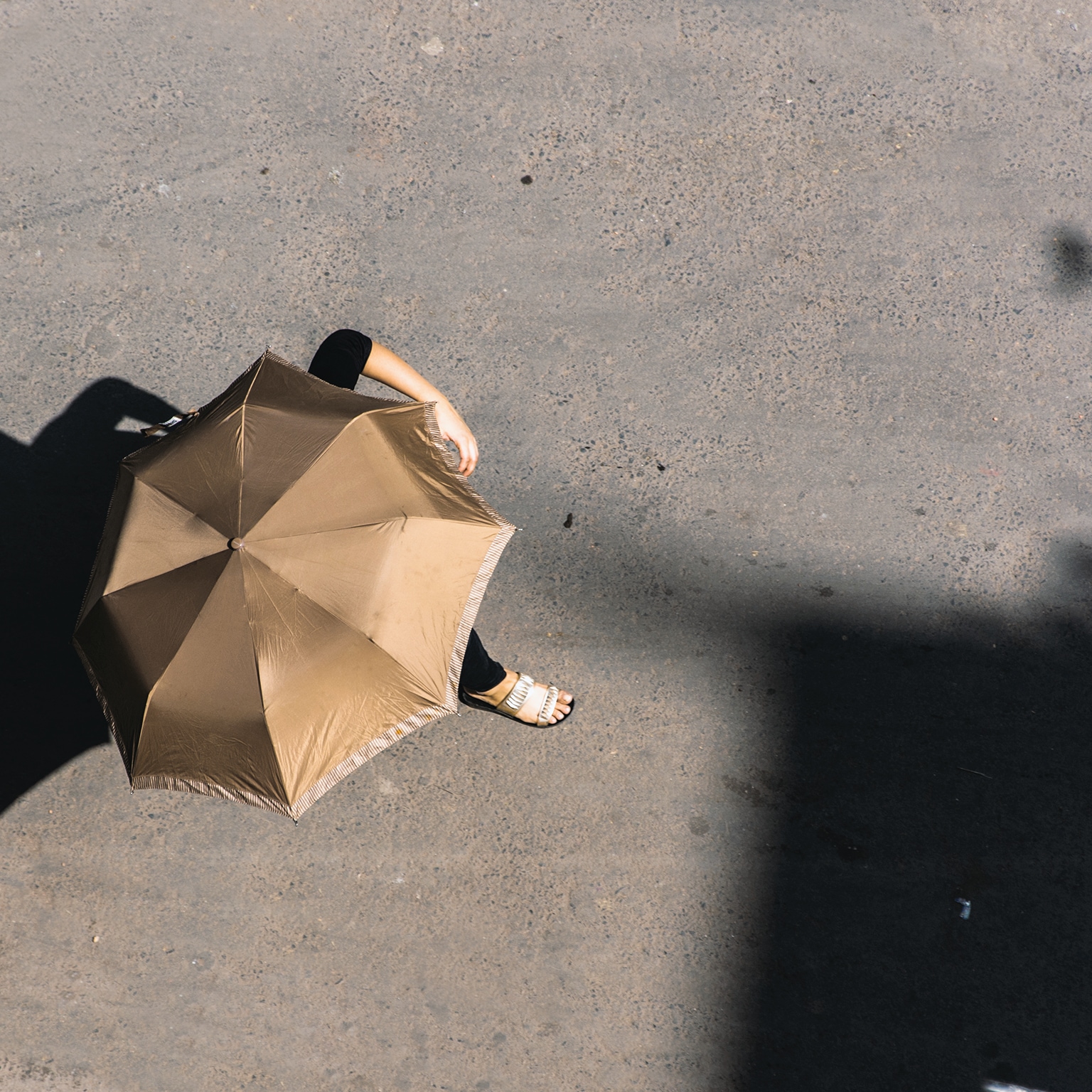 Woman using umbrella as shade from the sun