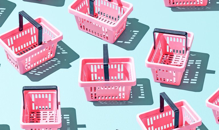 Assortment of pink plastic shopping baskets on a blue background.