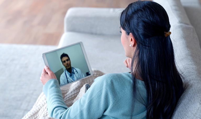 Woman at home feeling poorly and talking to her doctor on a video call