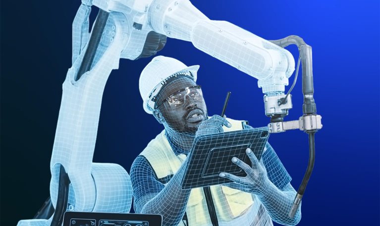 A worker wearing a hard hat, safety glasses, and a high-visibility vest holds a tablet at a workstation, with a large industrial robotic arm rising behind him. Both the worker and the robotic arm are partly rendered in a translucent blue wireframe, blending the two together. A laptop on the desk displays engineering schematics, set against a gradient blue background.