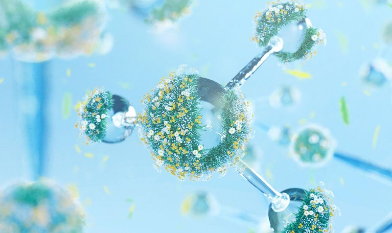 Molecular structure model with grass and flower on a light blue background.