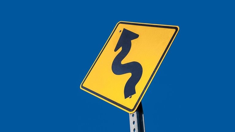 Winding road ahead warning sign