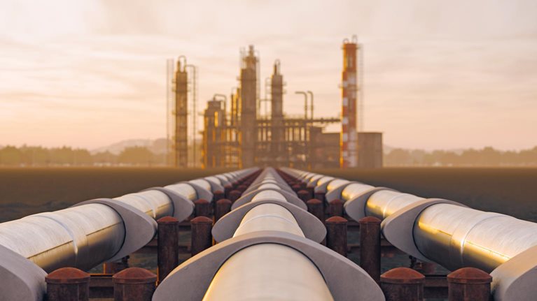 Oil refinery and pipeline in desert during sunset