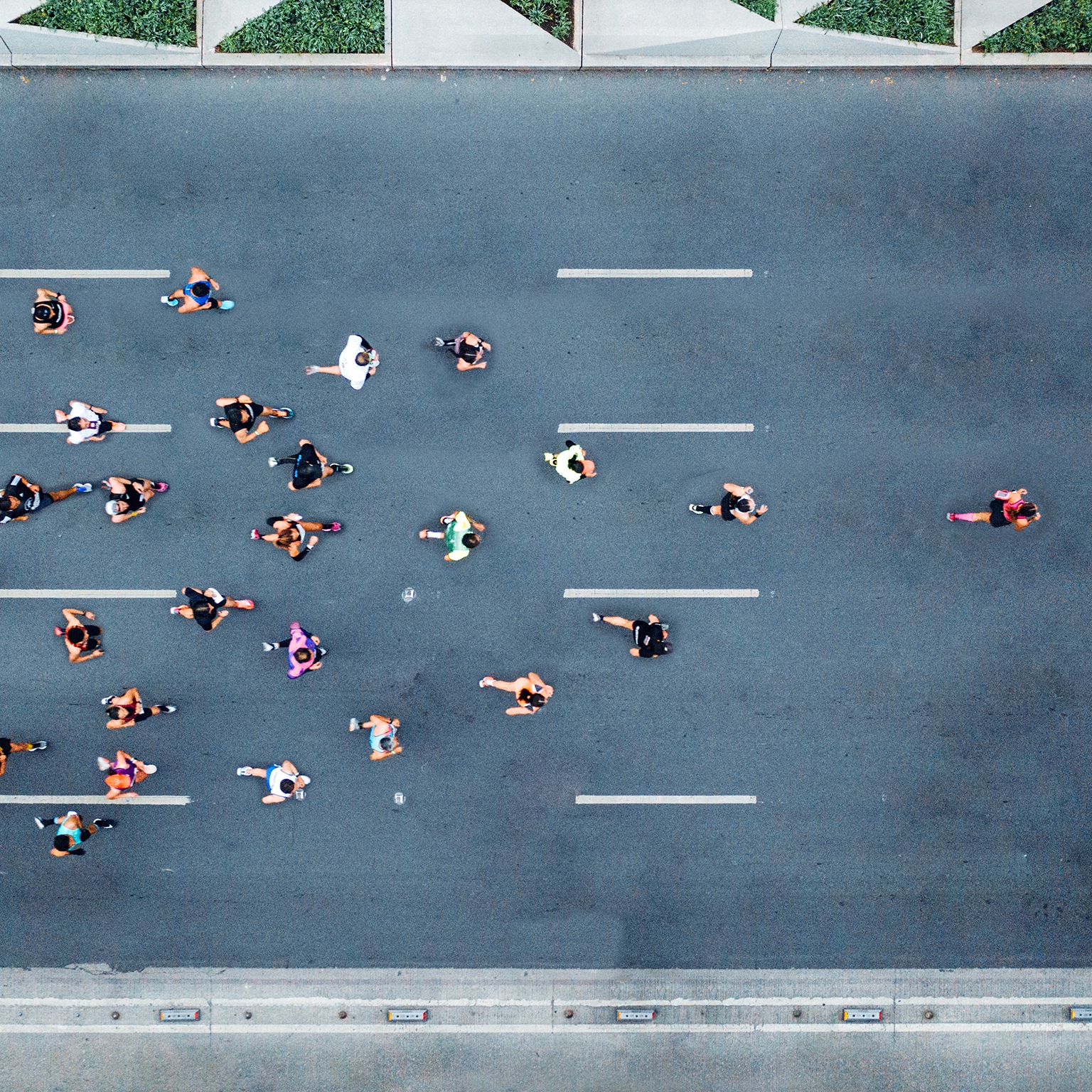  Aerial shot of marathon runners, with one runner leading the pack