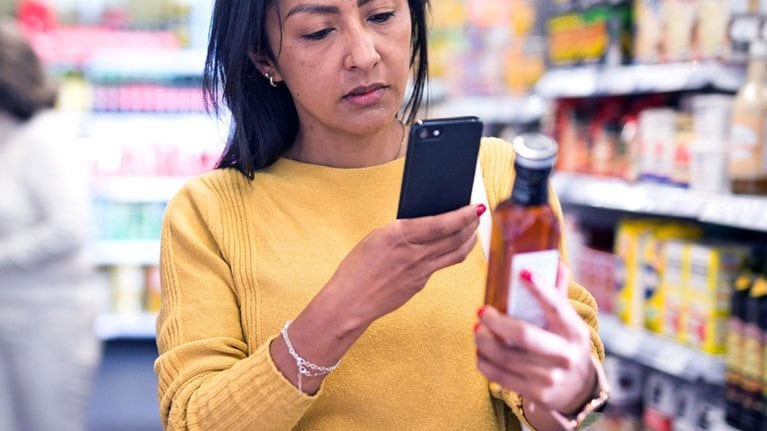 Woman holding phone in a grocery store