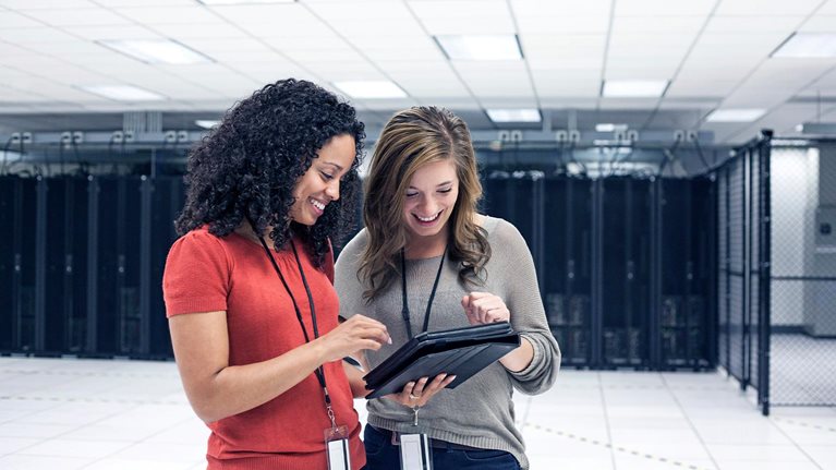 Businesswomen using tablet computer in server room