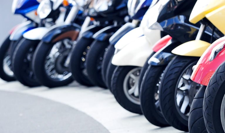 A row of motor scooters standing on the street