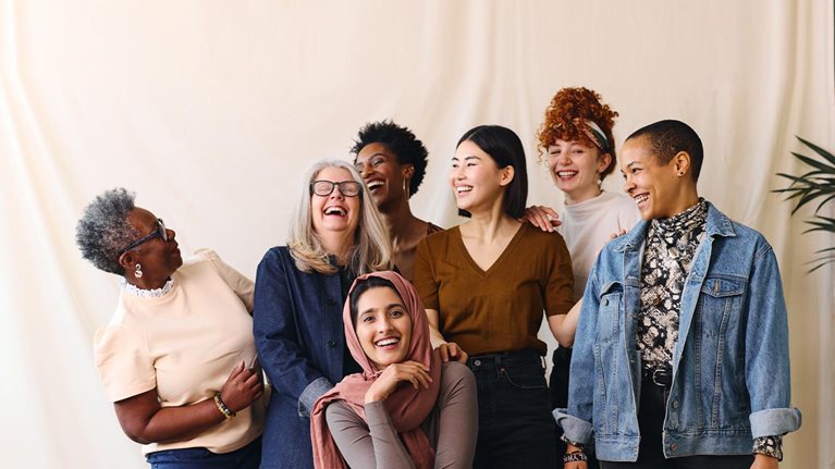Portrait of cheerful mixed age range multi ethnic women celebrating International Women's Day - stock photo