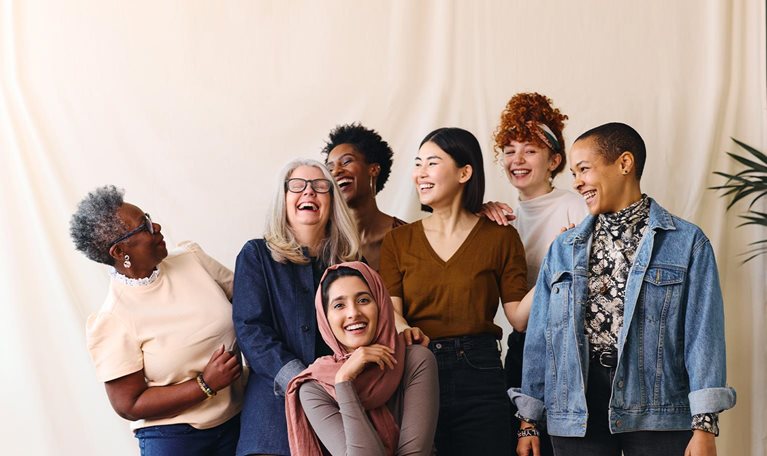 Portrait of cheerful mixed age range multi ethnic women celebrating International Women's Day - stock photo