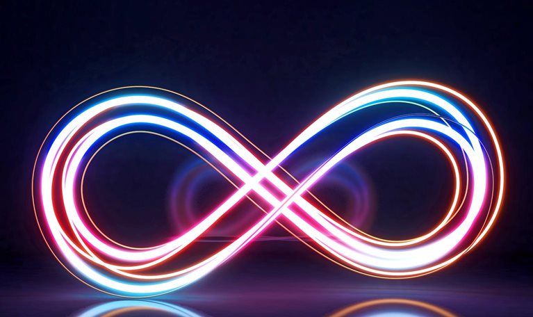 A glowing infinity symbol is formed by intertwined neon light trails in vibrant shades of pink, blue, and orange against a dark background.