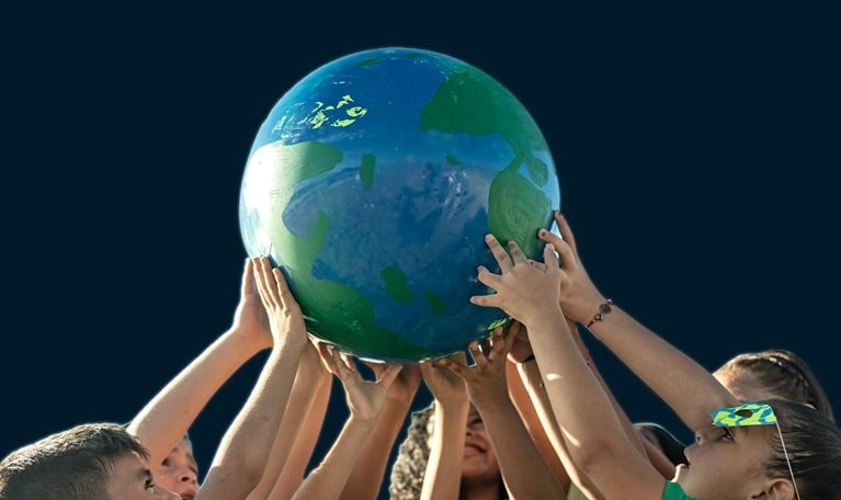 Children holding a planet outdoors - stock photo