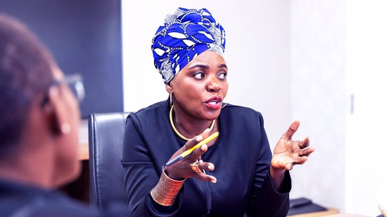 Successful African businesswoman chairing a meeting in a boardroom