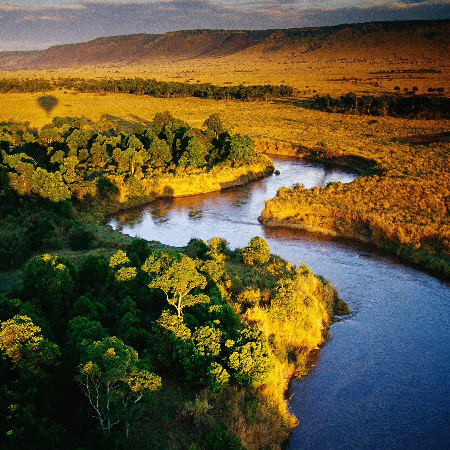 The view from the air, on a balloon safari over Masai Mara National Reserve in Kenya. The shadow of the balloon can be seen in the distance. - stock photo