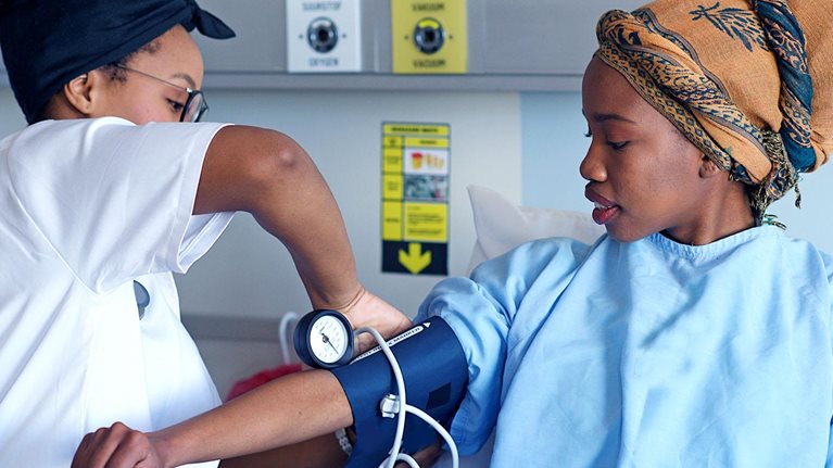 An African doctor taking a patient's blood pressure