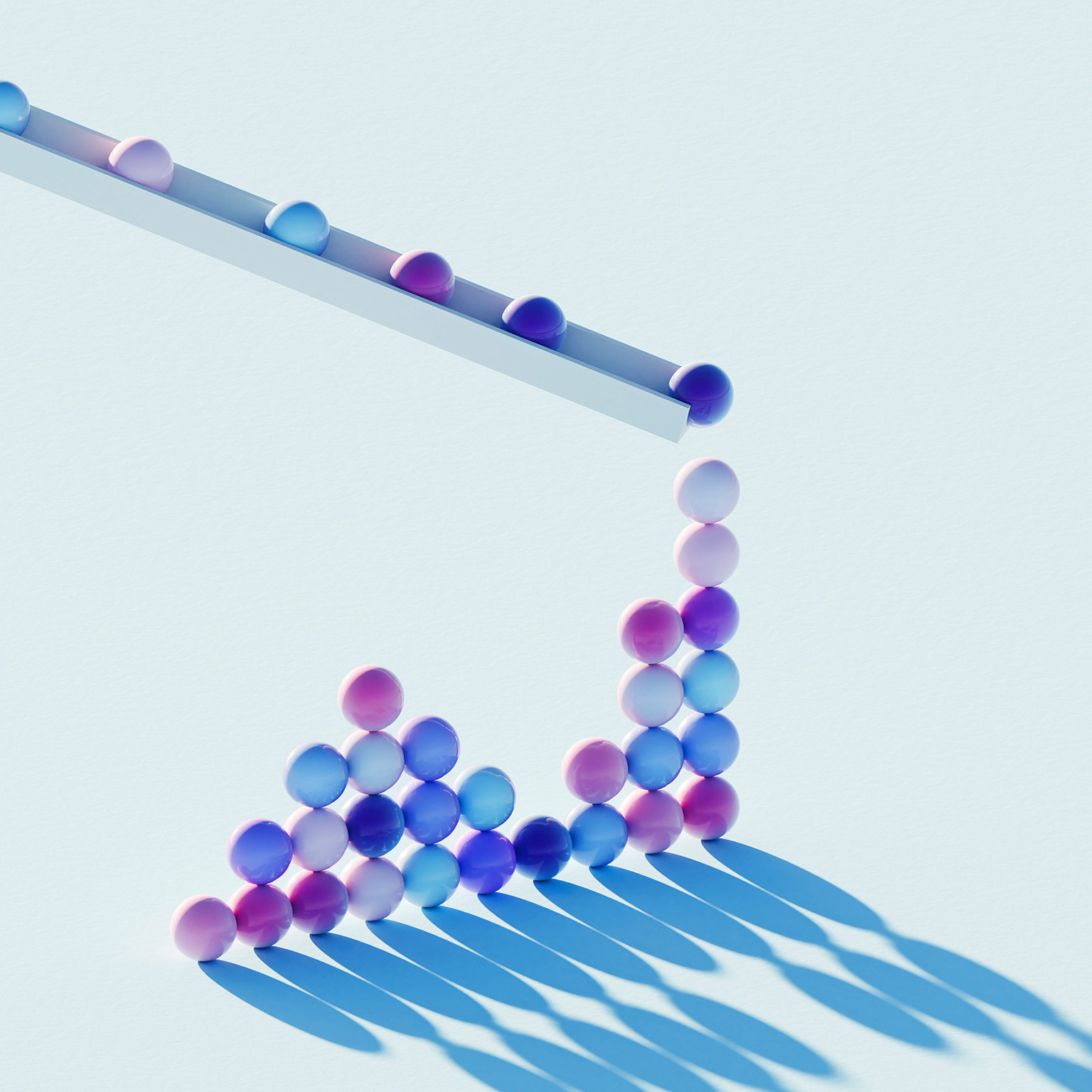 Colorful spheres roll off a slanted track and collect in a rising cluster on a light blue surface.