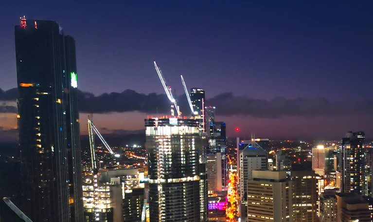 Aerial view Real time Footage of above Brisbane river over Kurilpa Bridge, Victoria Bridge and Captain Cook Bridge beside Modern Office Building at night time in Brisbane, Queensland, Australia, Business Financial Industry and Travel Destination Concept