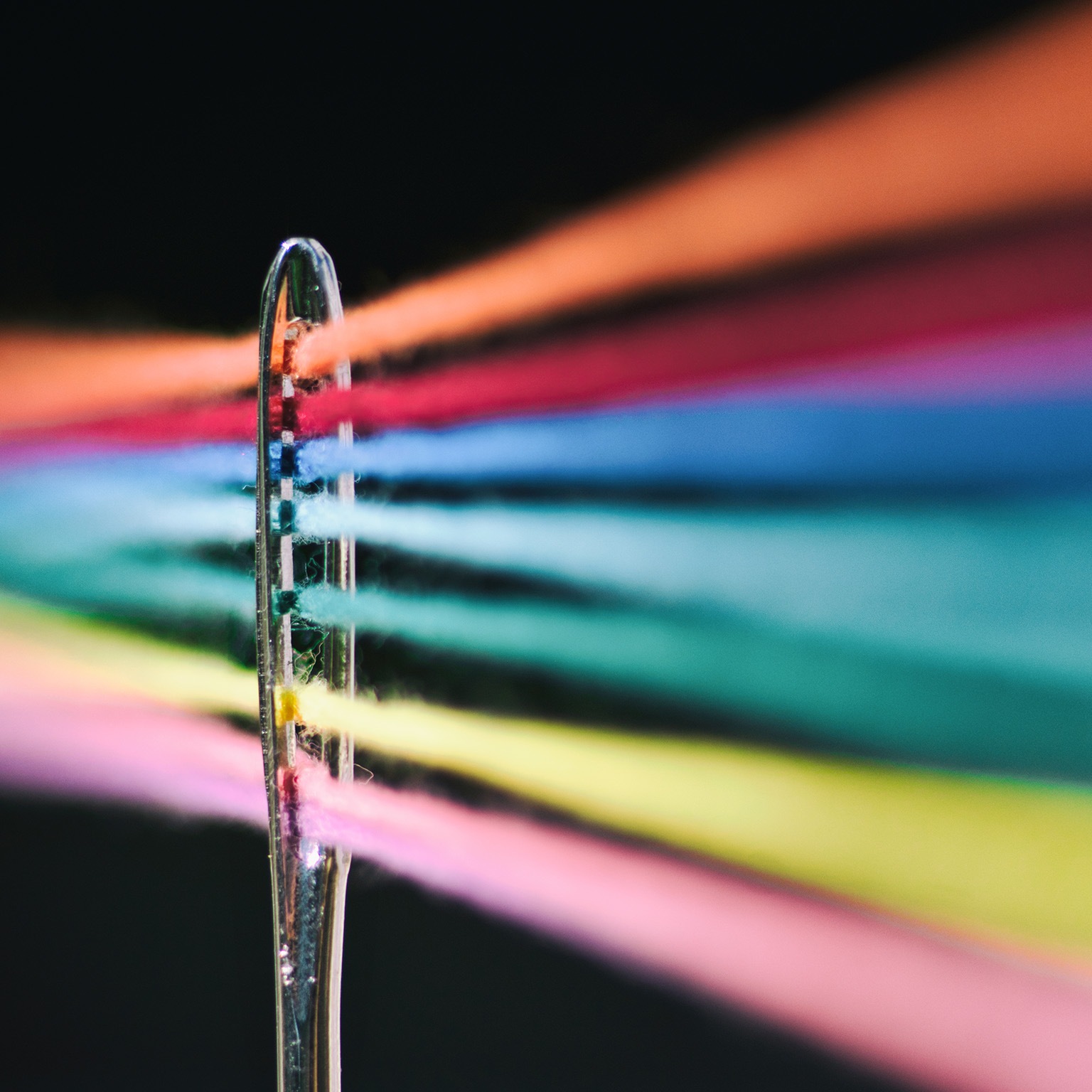 Needle of sewing and its colored threads - stock photo