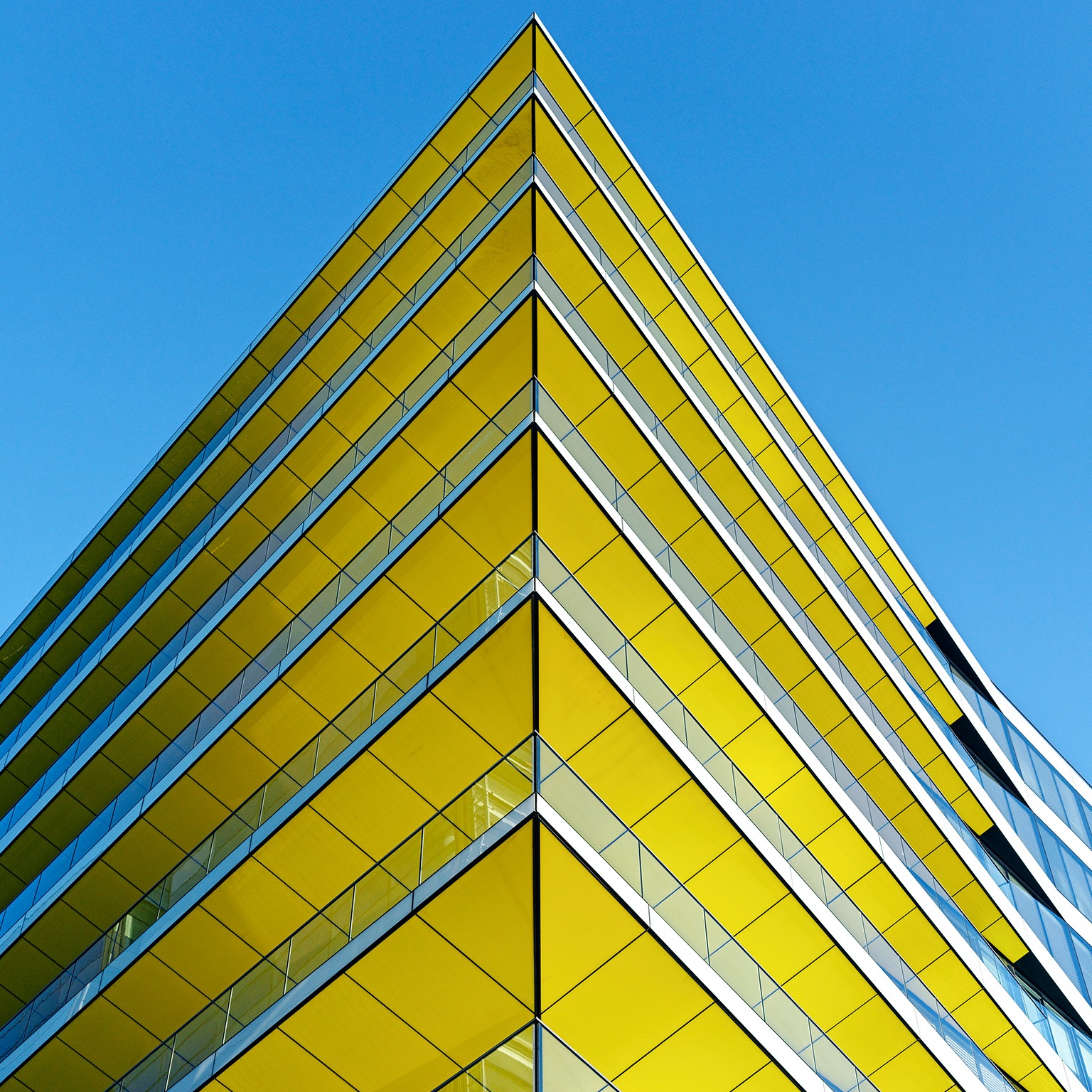 Low angle view of contemporary office building in Central London. Yellow ceilings, blue sky