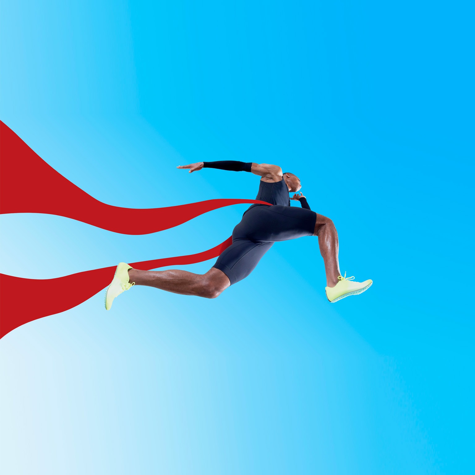 An Olympic runner crossing the finish line, the red ribbon fluttering behind him.