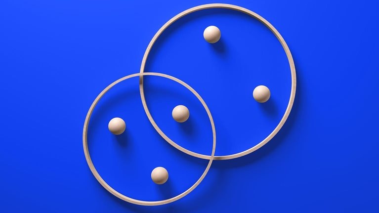 Interlocking contemporary wooden rings with embedded spheres, symbolizing a harmonious partnership, set against a vibrant blue background.