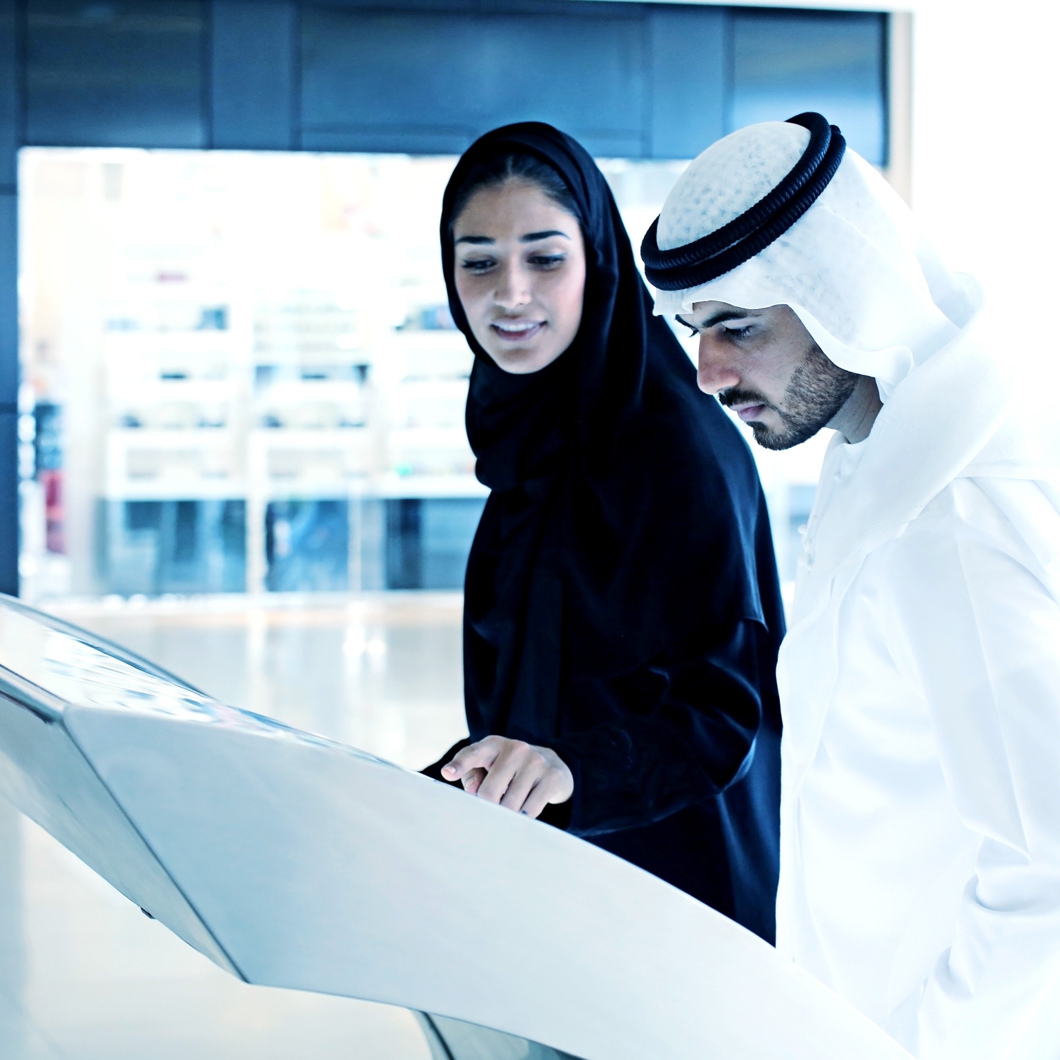Arab family using interactive screen of digital kiosk - stock photo