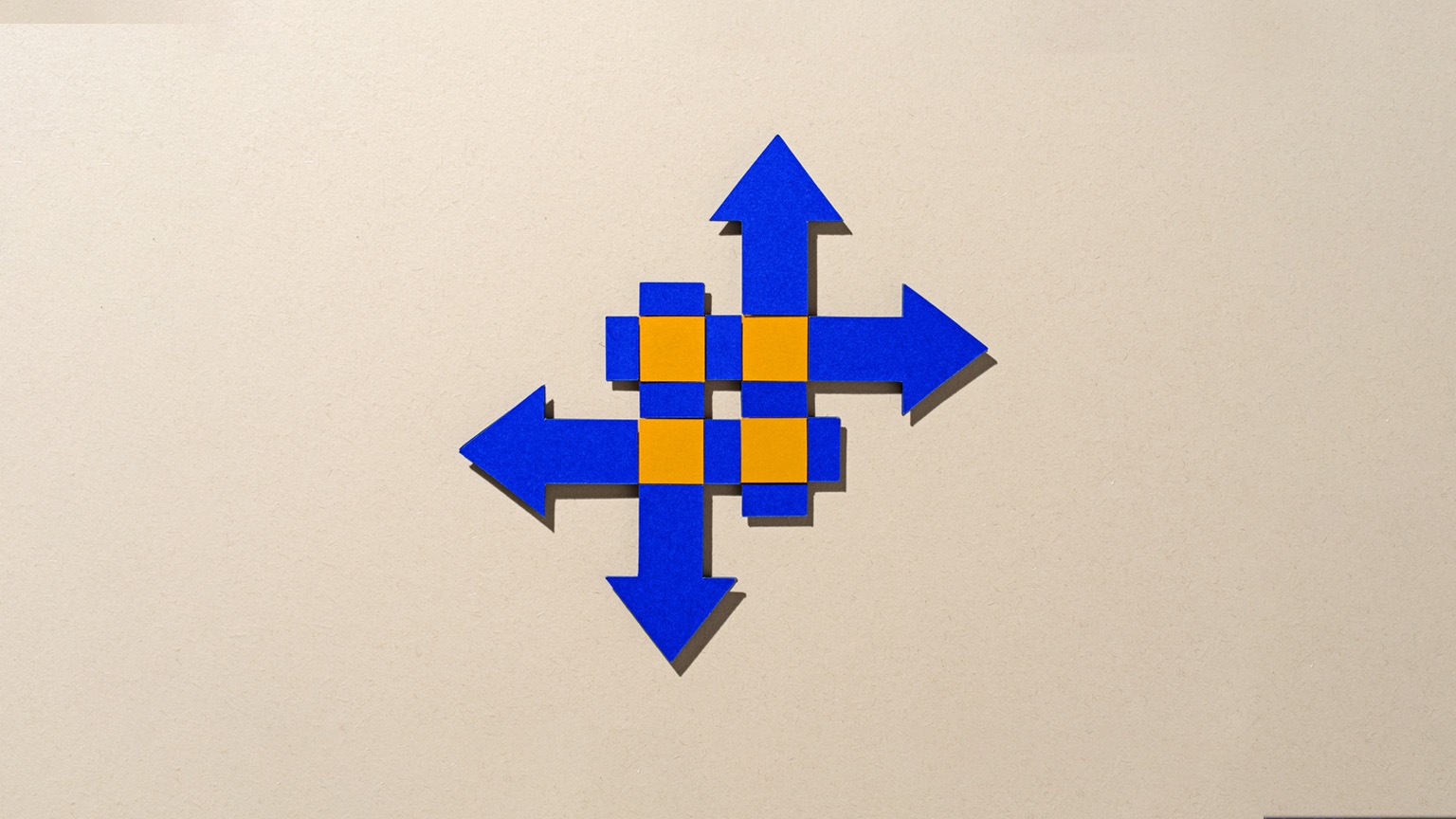 Paper-cut craft featuring four intersecting blue arrows on a beige background, with vibrant orange highlights at the crossover points, symbolizing the idea of merging and transformation