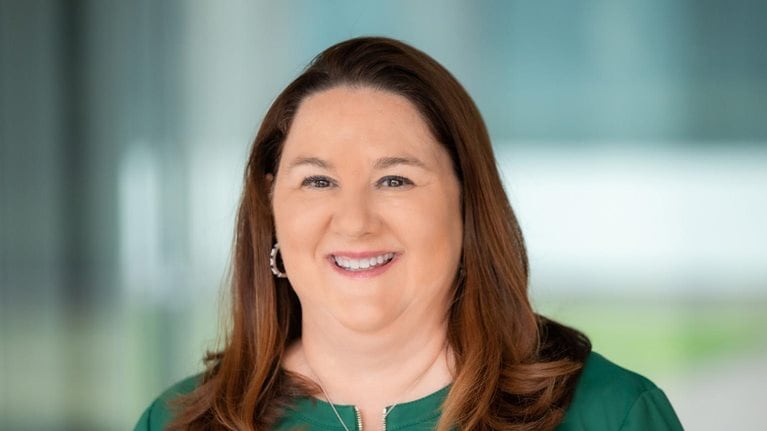 Lisa Blair Davis wearing a green business jacket and a smile on her face.