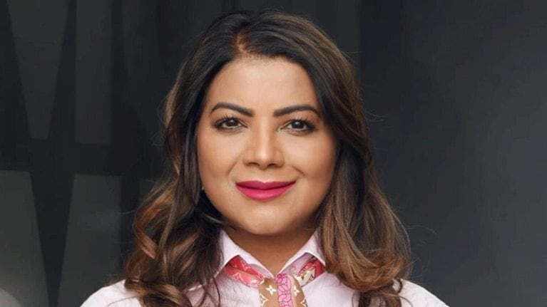 Jeniffer Ramnath with a light smile and wearing a pink top and patterned scarf.