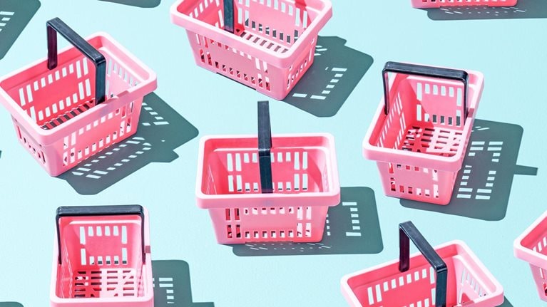 Assortment of pink plastic shopping baskets on a blue background.