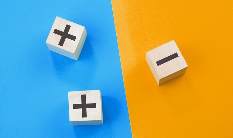 Image of 3d cubes with plus and minus signs on different sides of a colored background.