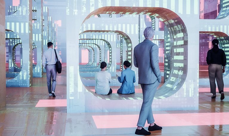 An image of a futuristic environment, with people walking and sitting among large, glowing geometric structures that serve as portals to digital structures.