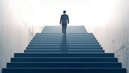 Ambitions concept with businessman climbing stairs - stock photo