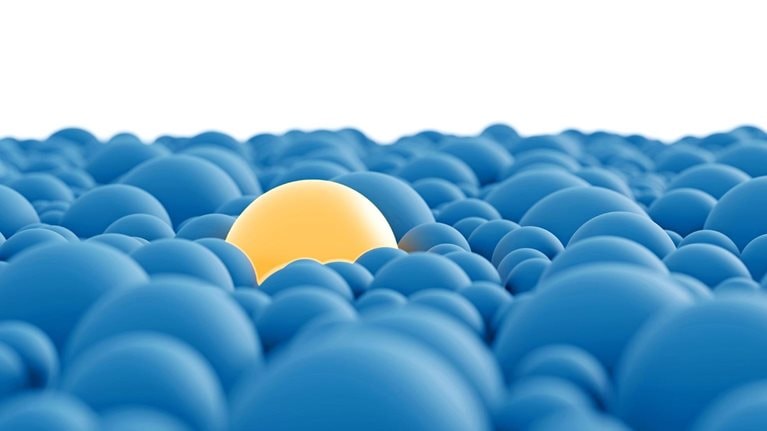 A group of closely clustered blue spheres with a conspicuous, larger yellow sphere in their midst.