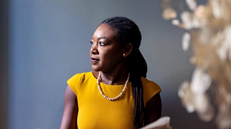 Woman in yellow holding a newspaper