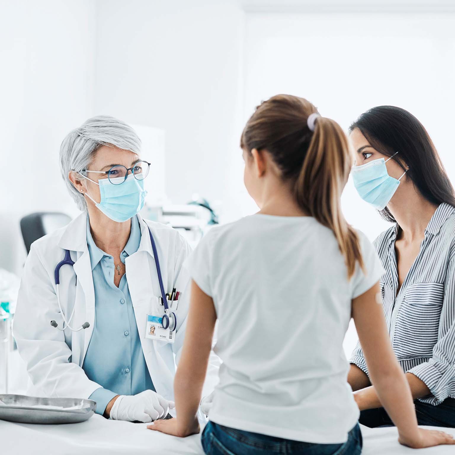 Woman and young girl sitting with a doctor in a doctor's office