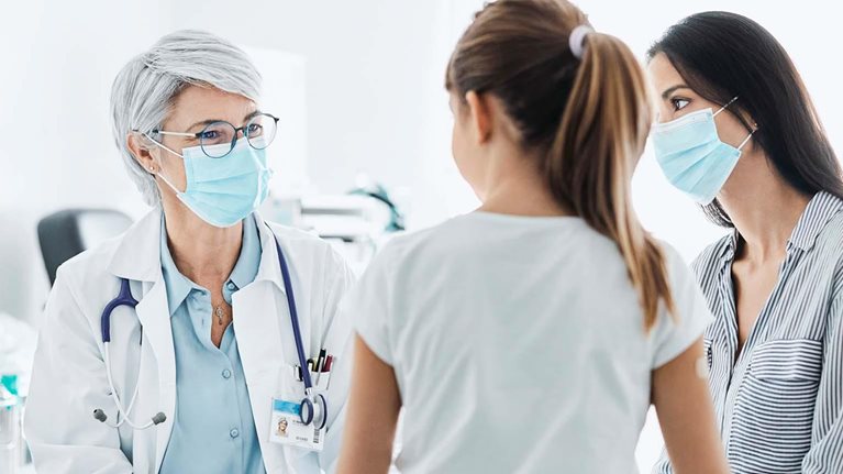 Woman and young girl sitting with a doctor in a doctor's office