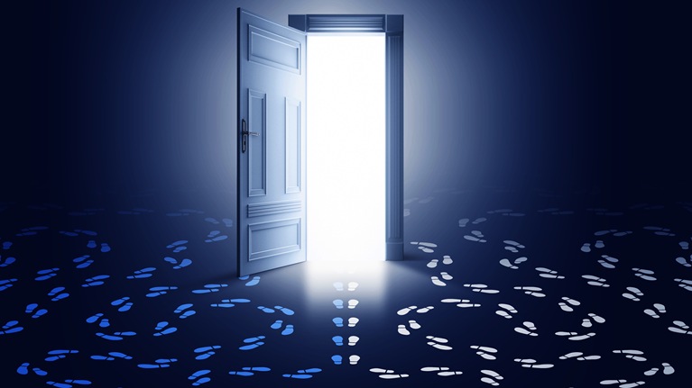 A glowing, open doorway with two sets of footprints with circling paths at either side and a third set of footprints heading through the door.