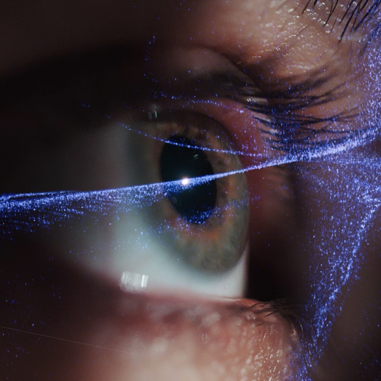 Close-up of a human eye, with glowing blue, digital particles swirling across the pupil and iris.